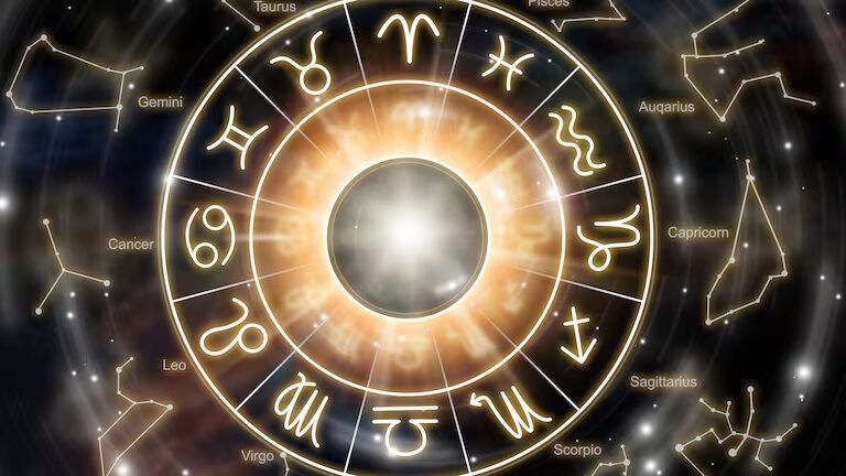 Los doce signos del zodiaco en una rueda entre luces rosas y azules