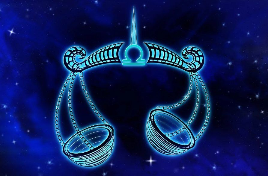 Los doce signos del zodiaco en una rueda entre luces rosas y azules