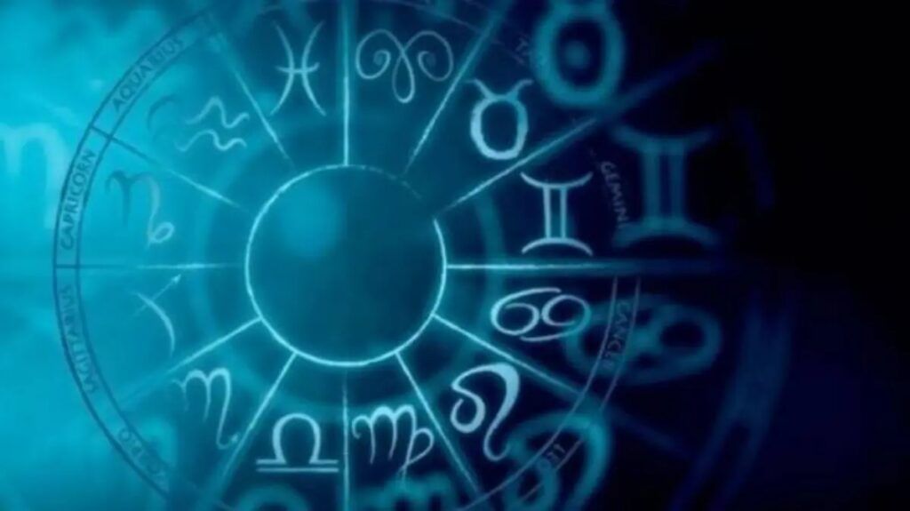 Los doce signos del zodiaco en una rueda entre luces rosas y azules