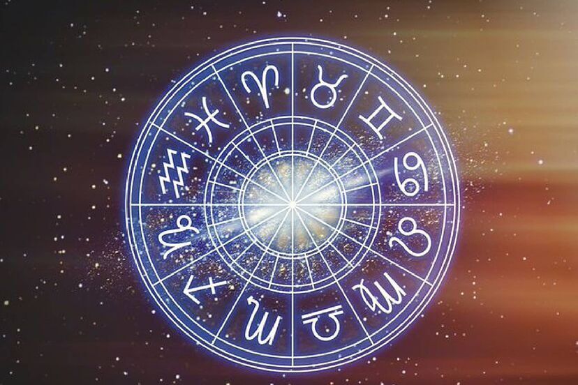 Los doce signos del zodiaco en una rueda entre luces rosas y azules