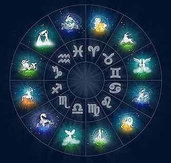 Una mano sostiene la rueda del zodiaco iluminada en azul